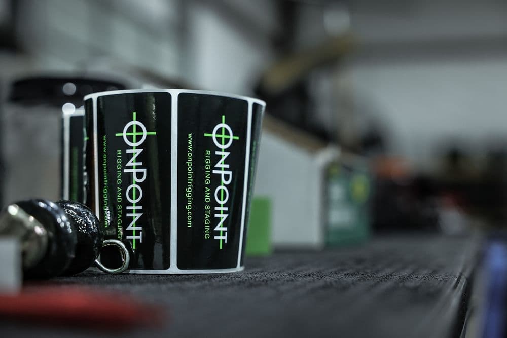 OnPoint branded rigging bag hanging from a shackle on a job site